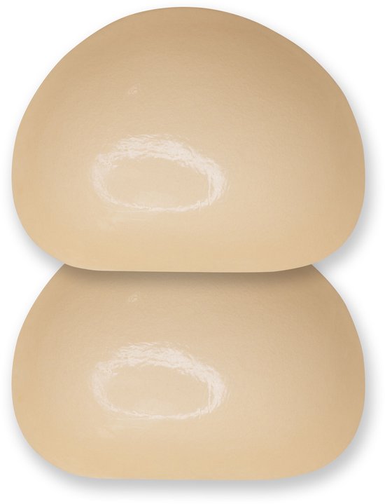 Twee huidkleurige, halve maanvormige push-up pads op elkaar, op een witte achtergrond.