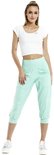 Model in mintgroene capribroek met wijde pijpen en witte crop top.
