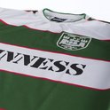 Detail van wit voetbalshirt met groene en witte strepen, rode bies en 'Guinness' opdruk.