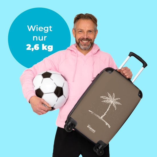 Man met roze hoodie en voetbal houdt bruine koffer met palmboom vast. Koffer weegt 2,6 kg.