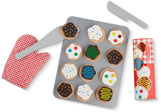 Houten koekjes op bakplaat met rode ovenwant, spatels en rol koekjesdeeg. Koekjes met sprinkles, chocolade, groene en blauwe icing, polka dots.