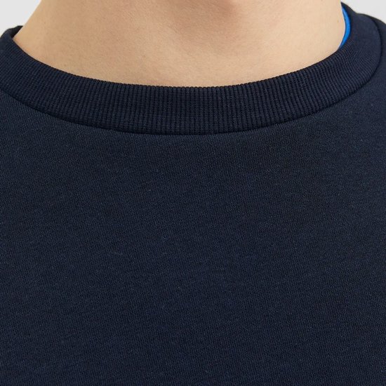Close-up van de ronde hals van een donkerblauwe sweater met blauwe voering.