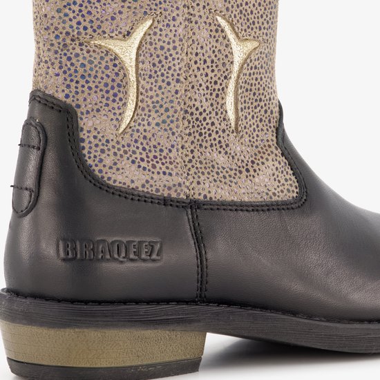 Detail van het logo 'BRAQEEZ' op een zwarte leren cowboylaars met beige/gouden glitter paneel.