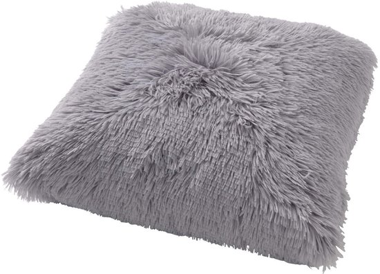 Un coussin décoratif fluffy gris clair avec de longues fibres douces, posé sur le côté.
