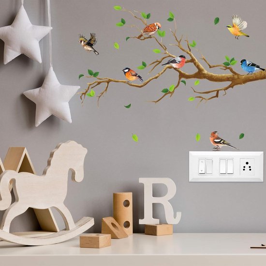 Muurstickers van vogels op een boomtak boven een kinderkamer bureau met houten decoratie.