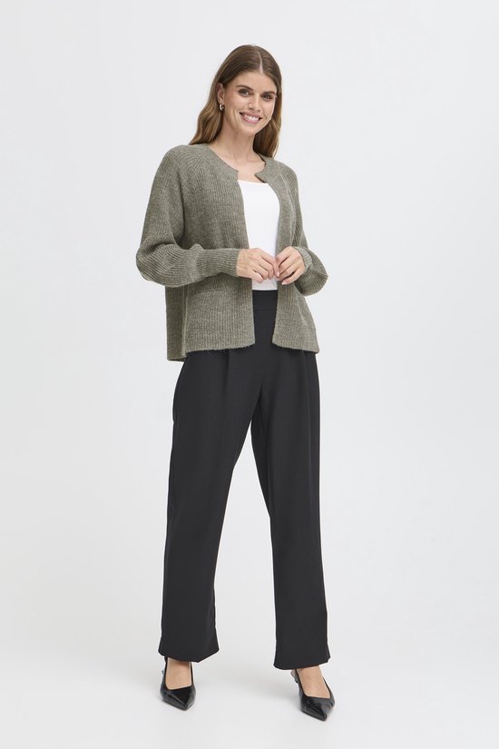 Mannequin de face portant un gilet vert chiné en maille, un haut blanc et un pantalon noir.