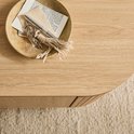Gros plan sur un plateau en bois clair avec un petit bol décoratif contenant des clés et des papiers.