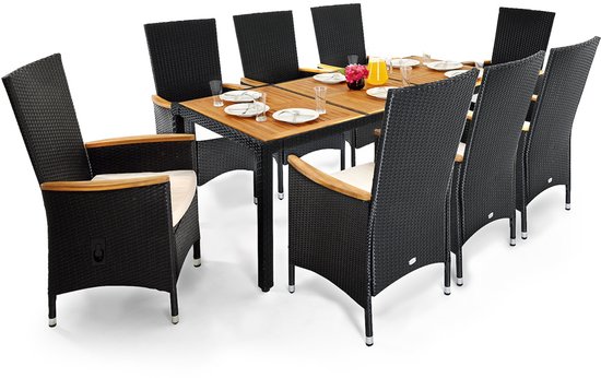 Zwarte polyrattan tuinset met acht stoelen met houten armleuningen en witte kussens, rond een tafel met houten tafelblad.