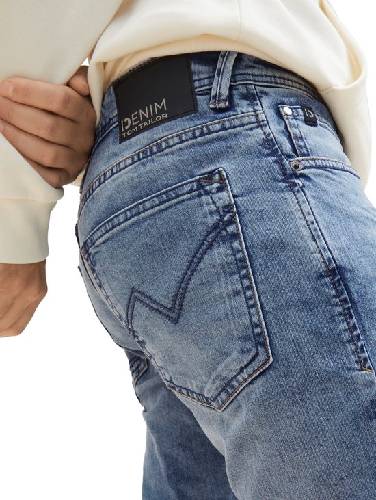 Blauwe denim jeans met een zwarte 'DENIM TOM TAILOR' patch op de achterkant.