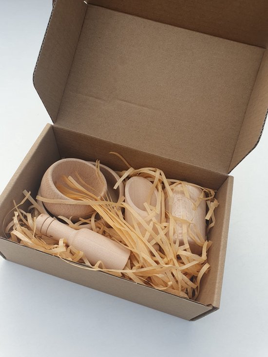 Houten speelgoedset met twee kommen, een stamper, twee schepjes en een tang, verpakt in stro in een kartonnen doos.