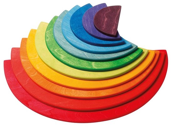 Een kleine regenboogstapel van houten schijven in regenboogkleuren op een witte achtergrond.