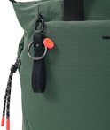 Detail van een donkergroene rugzak met "Hedgren" logo, sleutelhanger met oranje tag en trekkoord met rode uiteinden.
