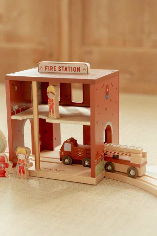 Gedetailleerd houten brandweerstation met een brandweerwagen, ladder, poppetjes en een hydrant.