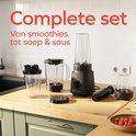Zwarte KitchenBrothers blender set met diverse accessoires op een houten aanrecht. Tekst 'Complete set'.