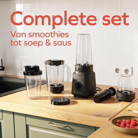 Zwarte KitchenBrothers blender set met diverse accessoires op een houten aanrecht. Tekst 'Complete set'.