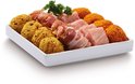 Een witte schaal met fonduespiesjes: stukjes vlees, spek, en krokets. Garnering van peterselie. Geel-oranje paneermeel.