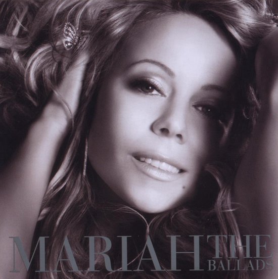 Close-up van Mariah Carey met krullend haar en sieraden, met de tekst 'MARIAH THE BALLADS'.