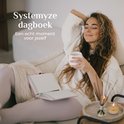 Vrouw ontspant op een bank met een roze dagboek en een kopje thee.