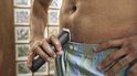 Man gebruikt zwarte Philips trimmer in de intieme zone.