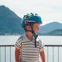 Lichtgroene kinderfietshelm met dinosaurusprint, drakenogen en scherpe tanden. Met gele accenten en verstelbare bandjes.