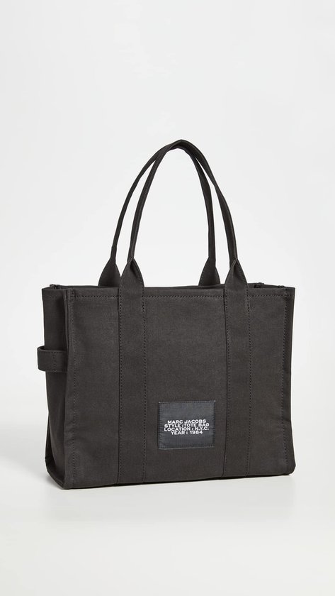 Zwarte canvas tas van Marc Jacobs met label met merknaam en type tas.