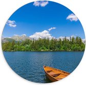 Dibond Muurcirkel - Houten Vissersbootje dobberend op het Water bij Bomen en Berg - 100x100 cm Foto op Aluminium Muurcirkel (met ophangsysteem)