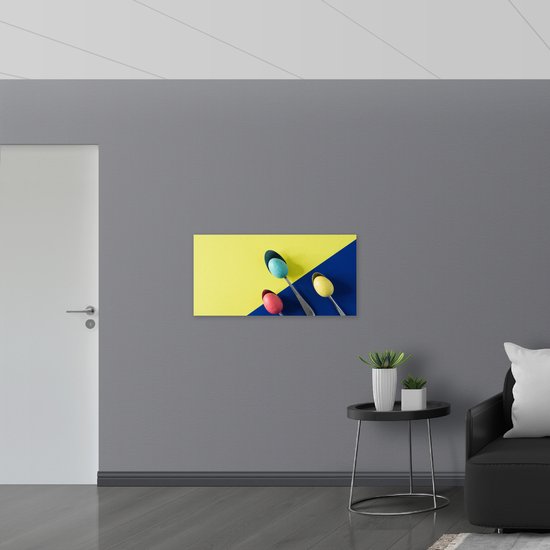 PVC Schuimplaat - Gekleurde Eieren op Lepels op Blauwe en Gele Vakken - 100x50 cm Foto op PVC Schuimplaat (Met Ophangsysteem)