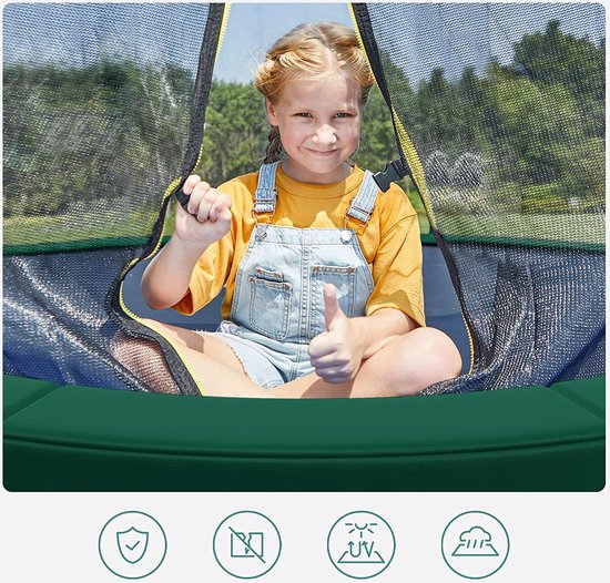 Een jong meisje met een gele T-shirt en een tuinbroek zit op een trampoline en geeft een duim omhoog.