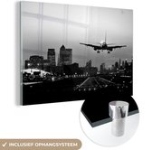 MuchoWow® Glasschilderij 120x80 cm - Schilderij acrylglas - Vliegtuig land in London - zwart wit - Foto op glas - Schilderijen