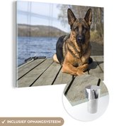 MuchoWow® Glasschilderij 120x90 cm - Schilderij acrylglas - Een Duitse Herder op een pier - Foto op glas - Schilderijen