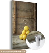 MuchoWow® Glasschilderij 40x60 cm - Schilderij acrylglas - Stapel van gele citroenen voor een rustieke kist - Foto op glas - Schilderijen