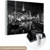 MuchoWow® Glasschilderij 180x120 cm - Schilderij acrylglas - De avondlichten steken het kanaal in Groningen aan - zwart wit - Foto op glas - Schilderijen