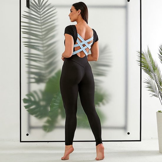 Model in zwart jumpsuit met korte mouwen en een open rug met lichtblauwe bandjes.
