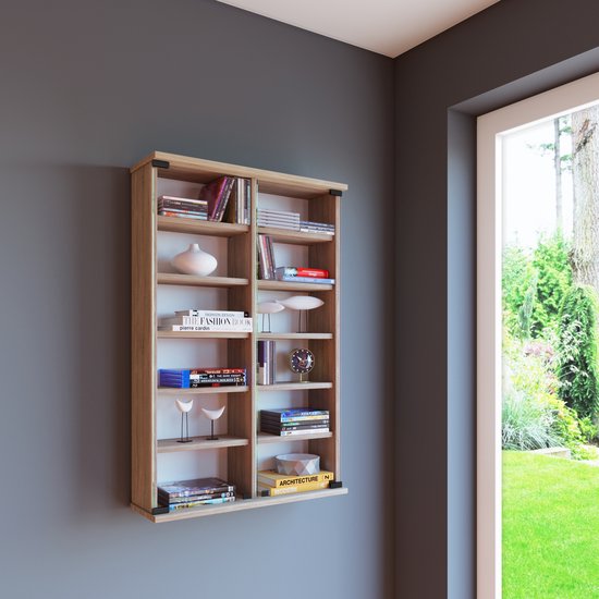 Une bibliothèque étroite et haute en bois clair, montée sur un mur gris foncé à côté d'une fenêtre donnant sur un jardin.