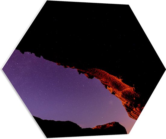 PVC Schuimplaat Hexagon - Silhouet van Grote Rots onder Sterrenhemel met Paarse Gloed - 80x69.6 cm Foto op Hexagon (Met Ophangsysteem)