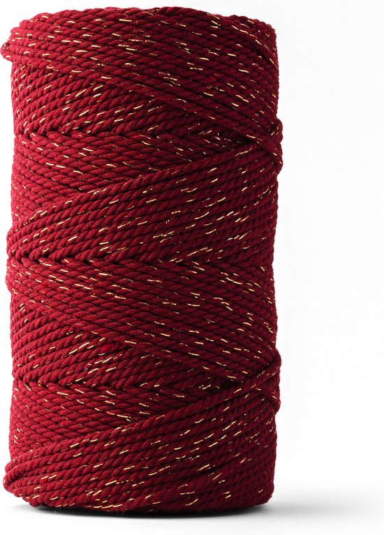 Un rouleau de corde macramé bordeaux avec des fils dorés brillants.
