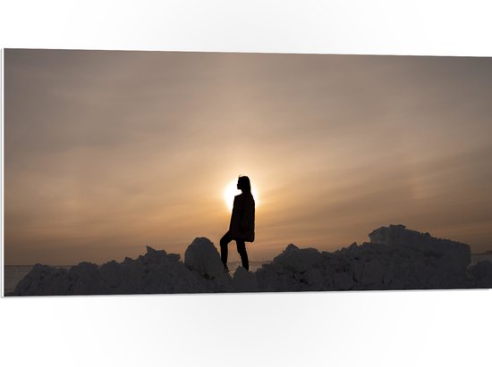 WallClassics - PVC Schuimplaat- Silhouet van Vrouw op Hoop Sneeuw - 100x50 cm Foto op PVC Schuimplaat