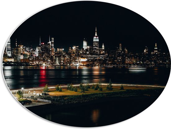 PVC Schuimplaat Ovaal - Skyline in New York in de Nacht - 68x51 cm Foto op Ovaal (Met Ophangsysteem)