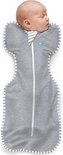 Baby slaapt in grijze Swaddle UP slaapzak met strepenranden op witte achtergrond.