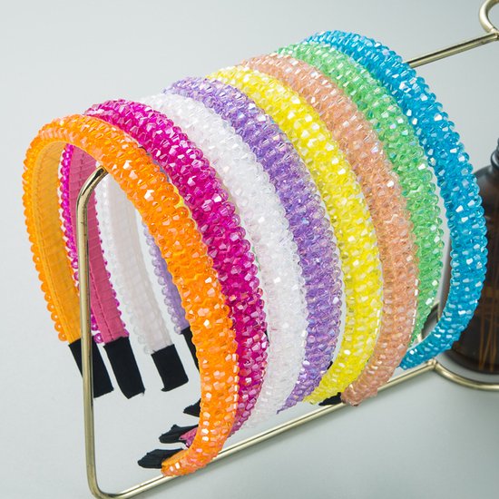 Rijen felgekleurde haarbanden met strass steentjes: oranje, roze, wit, paars, geel, perzik, groen, turquoise.