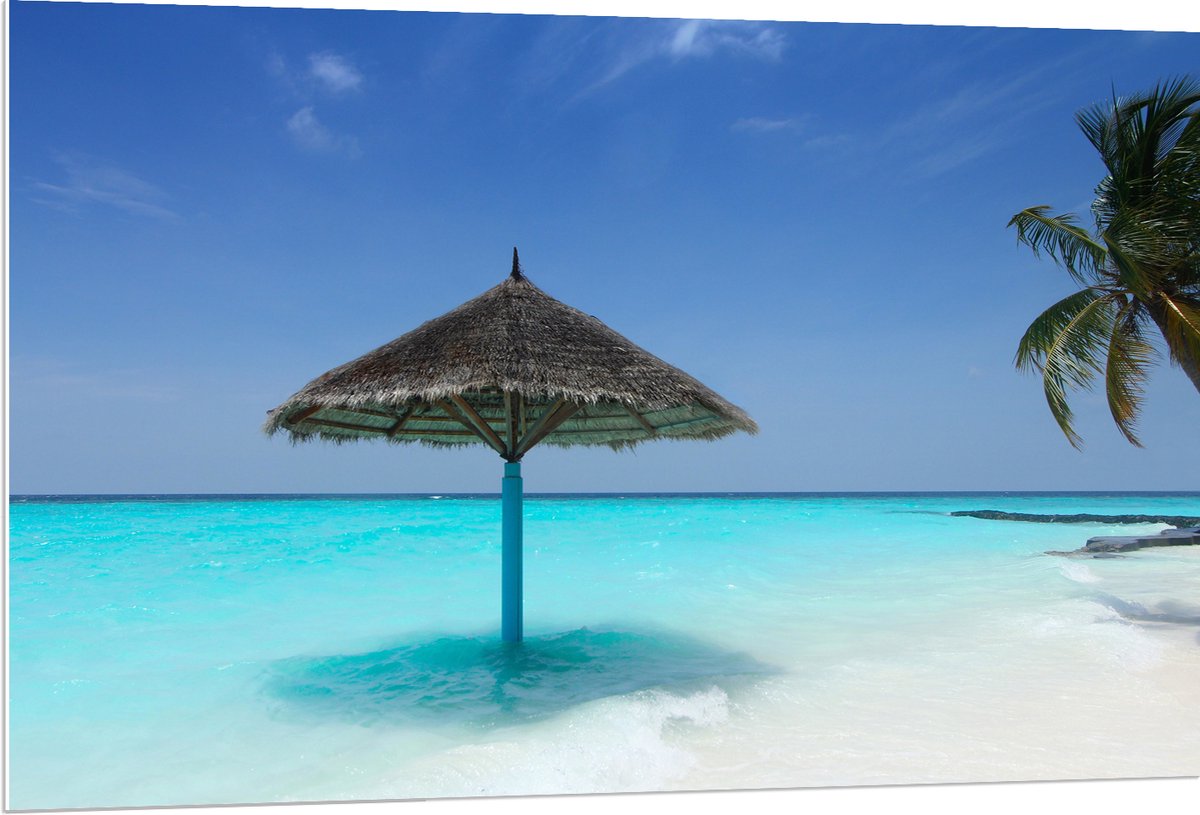 PVC Schuimplaat- Rieten Parasol op het Strand bij het Blauwe Water - 120x80 cm Foto op PVC