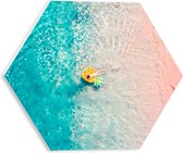 PVC Schuimplaat Hexagon - Bovenaanzicht van Vrouw Liggend op Floatie in Heldere Oceaan - 30x26.1 cm Foto op Hexagon (Met Ophangsysteem)
