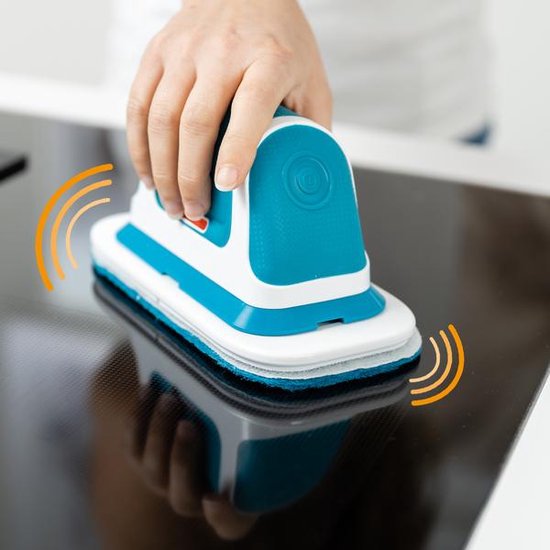Hand met de blauw-witte Livington MultiScrubber op een glanzend zwart fornuis.