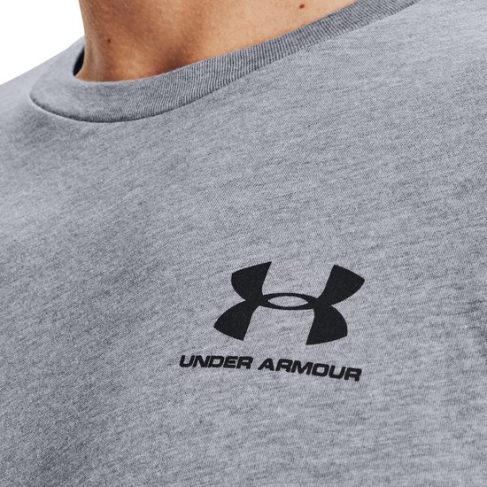 Detailopname van een grijs Under Armour t-shirt met zwart Under Armour logo en tekst op de linkerborst.