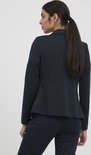 Achterkant van een vrouw met een paardenstaart, draagt een marineblauwe blazer en bijpassende broek.