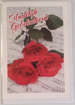 Hartelijk gefeliciteerd! Een mooie kaart met drie rode rozen die op muzieknoten liggen. Een leuke wenskaart om zo te geven of om bij een cadeau te voegen. Een dubbele wenskaart inclusief envelop en in folie verpakt.