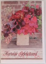 Hartelijk gefeliciteerd! Een mooie wenskaart met een enorme bos bloemen op tafel in allerlei kleuren. Een leuke kaart om zo te geven of om bij een cadeau te voegen. Een dubbele wenskaart inclusief envelop en in folie verpakt.