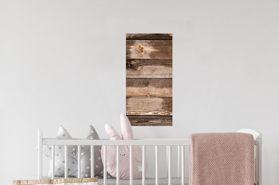 Planches verticales en bois brun avec des nœuds et des zones usées, suspendues au-dessus d'un lit d'enfant.