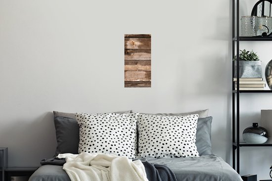 Planches verticales en bois brun avec des nœuds et des zones usées, suspendues au-dessus d'un lit avec des coussins.
