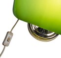 Gros plan de l'interrupteur et du culot doré d'une lampe de bureau verte.